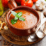 Chilled tomato soup with diced vegetables, served in a bowl